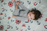 Child lying on a blanket with nautical patterns