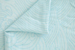 Close-up of light blue fabric with subtle pattern