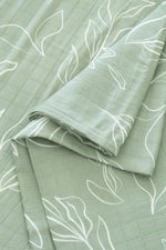 Green blanket with white leaf patterns on a matching background