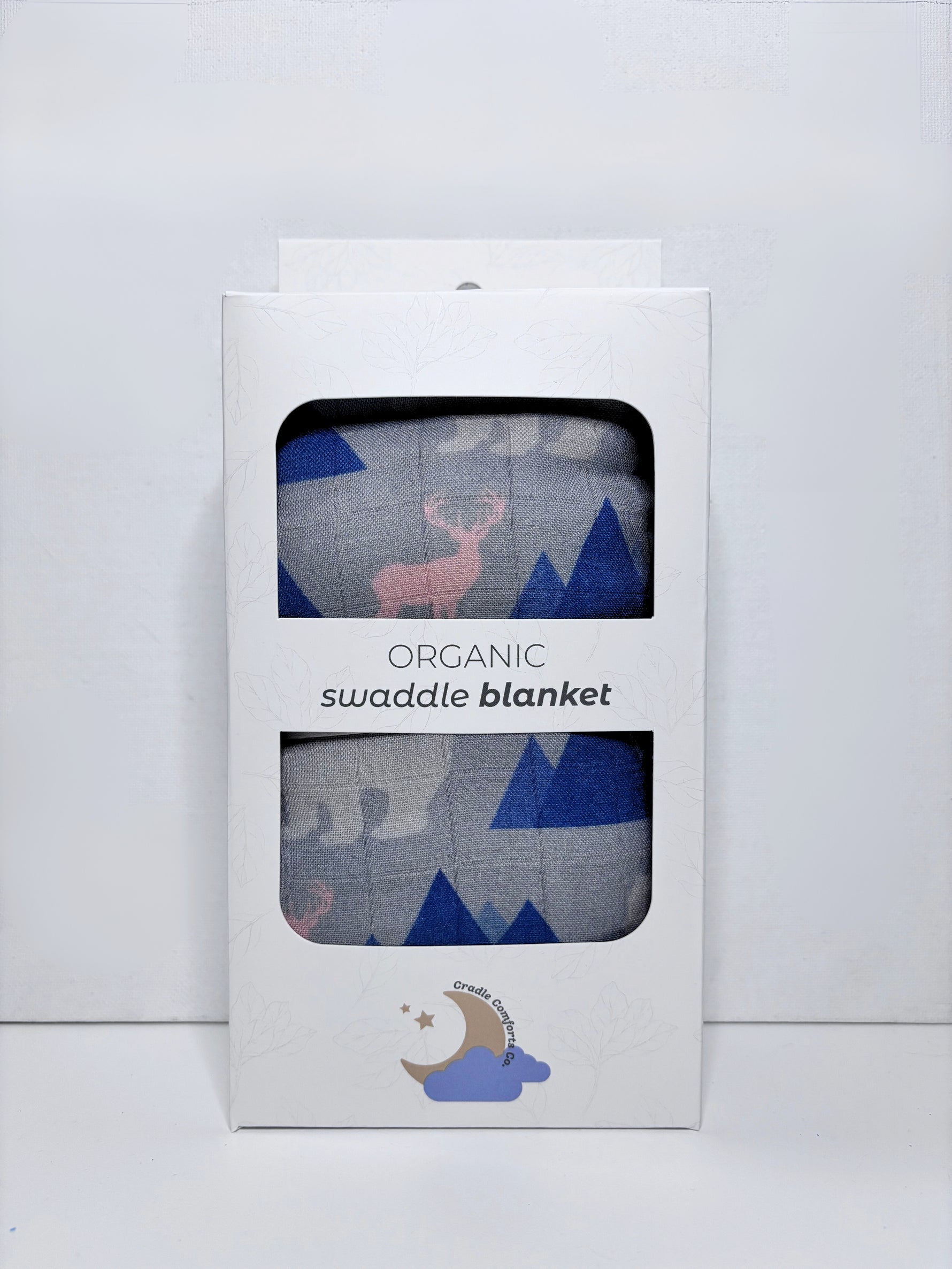 Organic swaddle blanket packaging with deer and mountain design on a white background